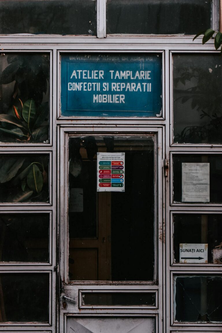 Old workshop entrance with detailed signage and worn wooden doors.